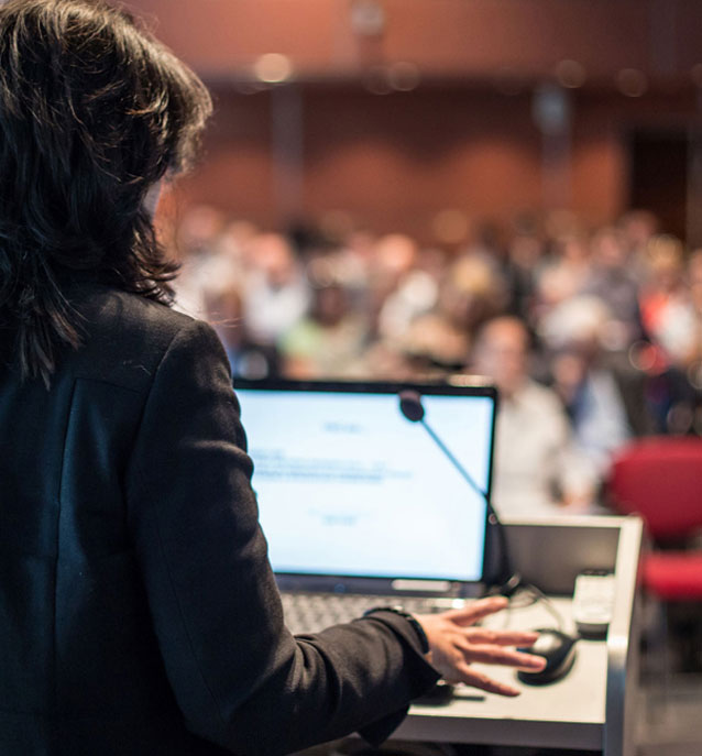 Blurred female in a black suit giving a speech