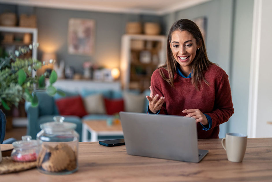 Woman in red sweater sitting at a laptop