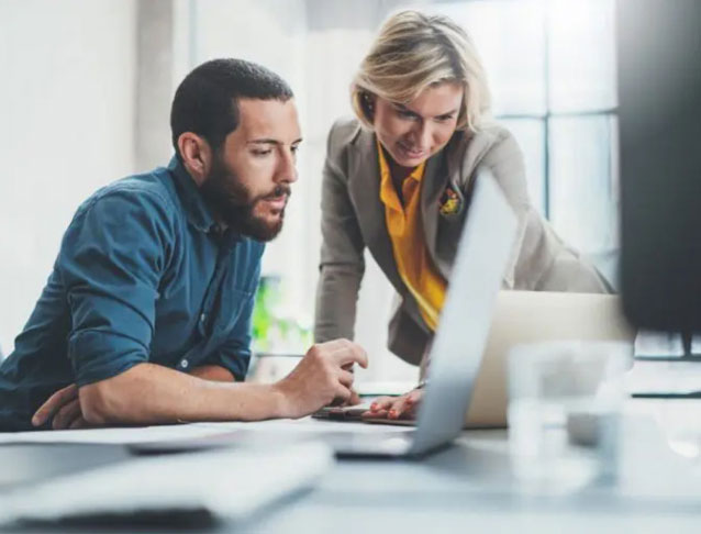 Two people looking at a laptop