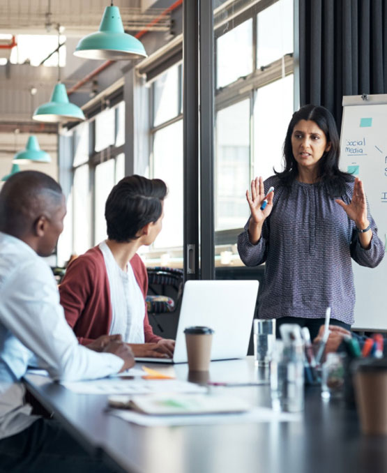 A woman presenting to 2 colleagues.